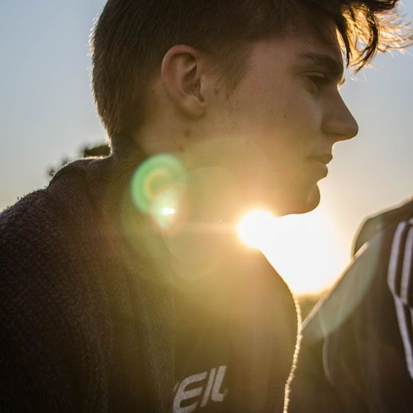 Person feeling energetic and stretching outdoors with a golden sun flare.